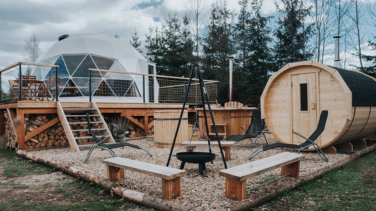  Venku se rozpíná prostorná terasa, kempingové hnízdečko s ohništěm, lavičkami i lehátky.