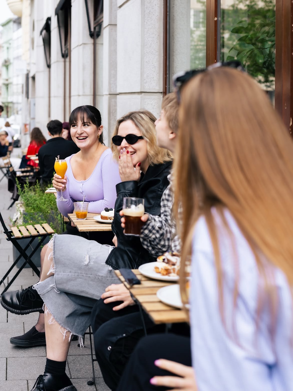 Slunná zahrádka SKØG Urban Hub s výhledem do ulice na styl pařížských kaváren