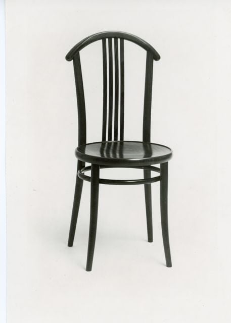 E-5797, Josef Macek, 1989 - Židle s úsporným děleným opěradlem, další varianta byla navržena s čalouněným sedákem a úzkým čalouněným dílem v opěradle