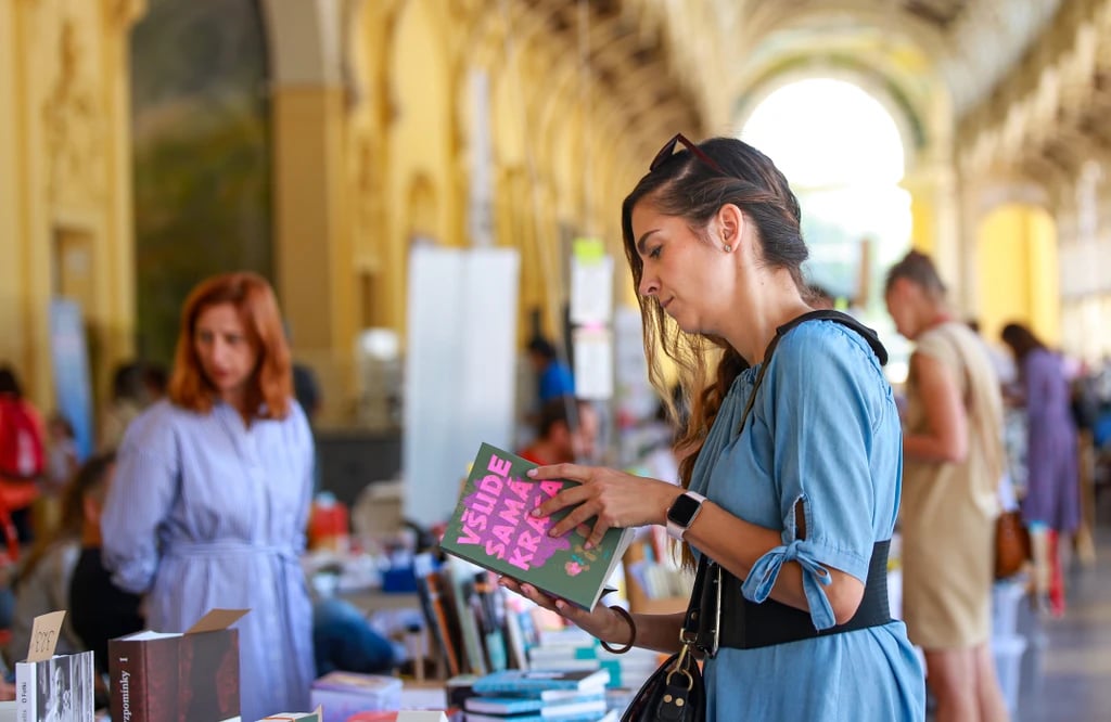 Účastnice si prohlíží knihu na Knižních lázních
