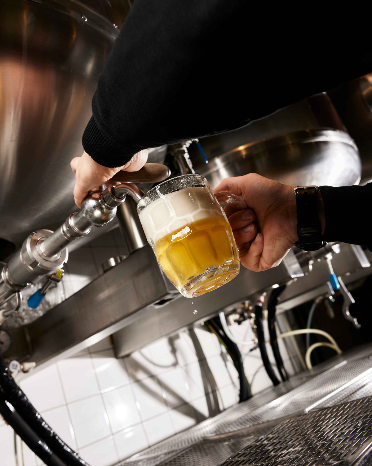 Čepování světlého piva z tanku do půllitru s hustou pěnou.