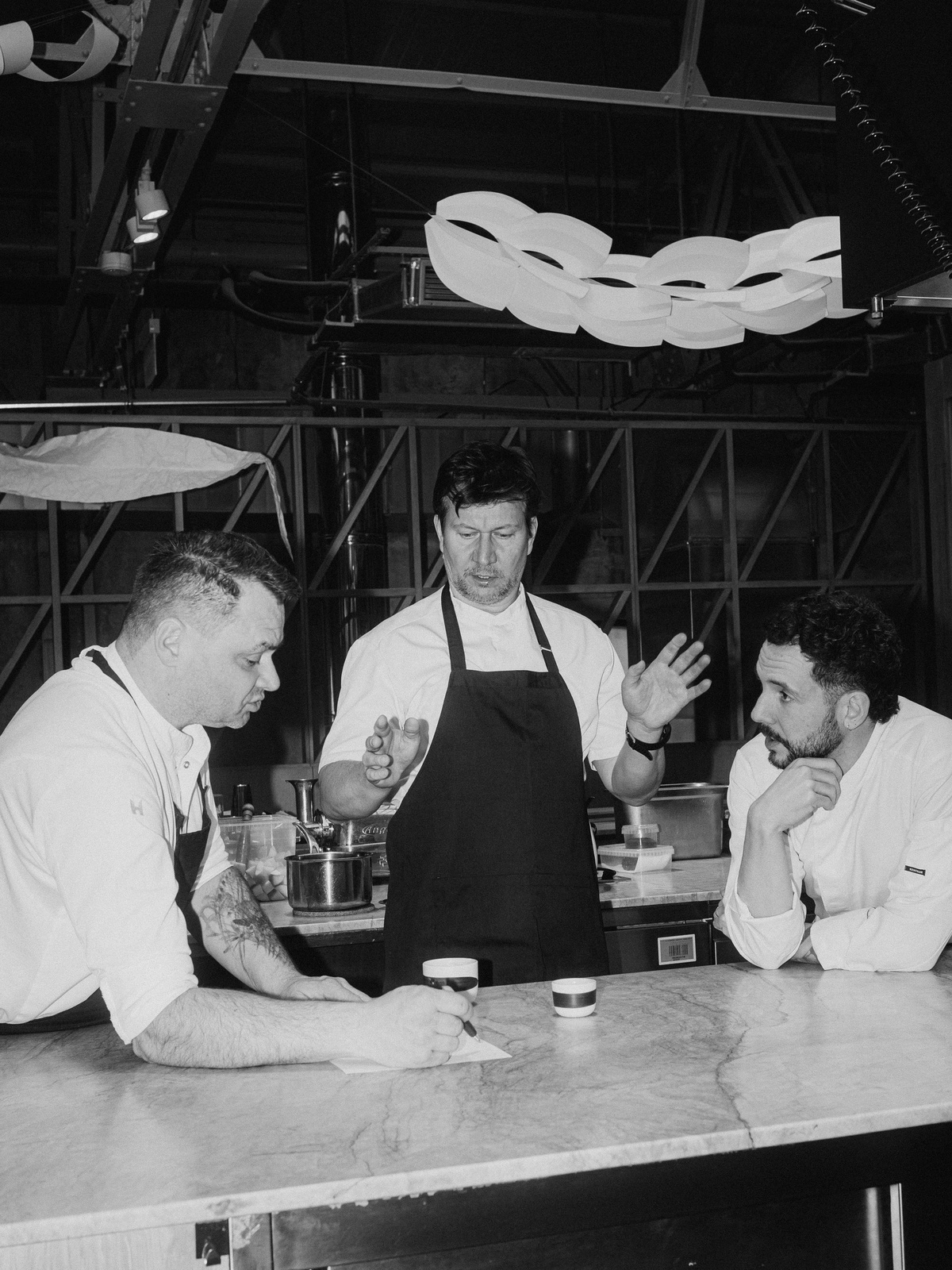 Šéfkuchaři Martin Štangl, Oldřich Sahajdák a Otto Vašák při společné přípravě menu v kuchyni během pop-up večeře