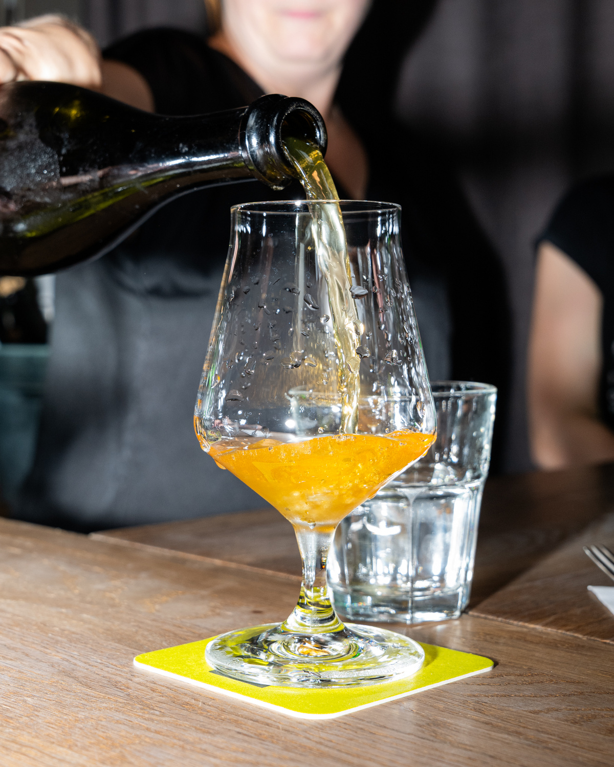 Nalévání řemeslného cideru do degustační sklenice v baru