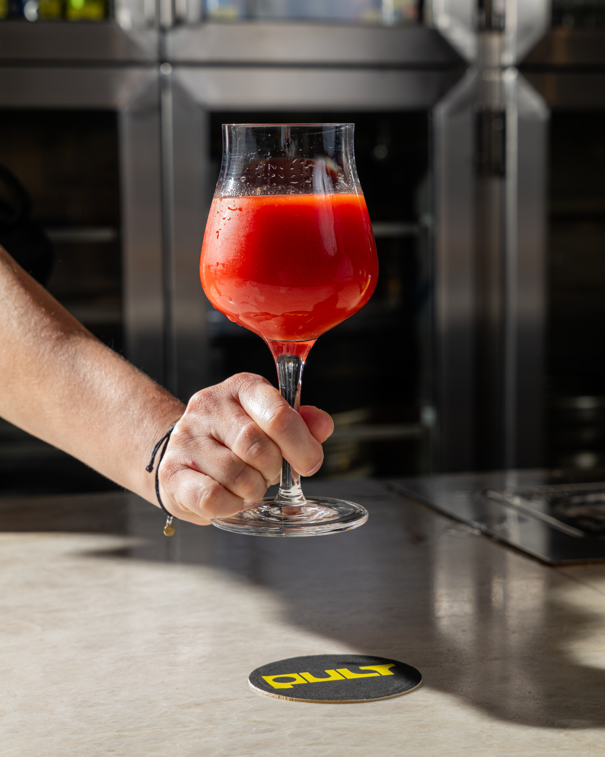 Gose Pomidor 18° – rajčatové pivo se solí, česnekem a paprikou ve sklenici na barovém pultu.