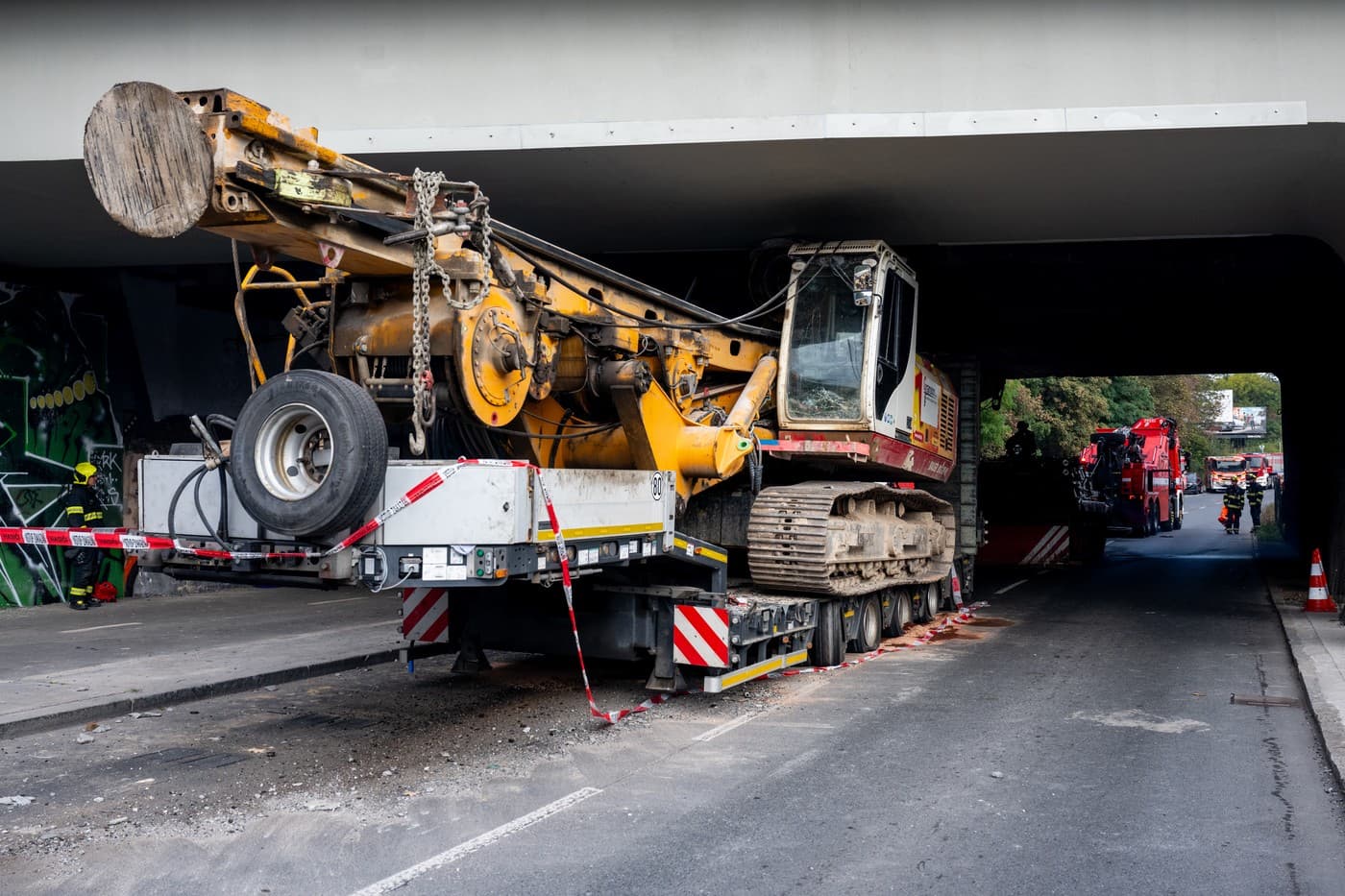 Vyprošťování kamionu s naloženou vrtnou soupravou uvázlého pod železničním mostem