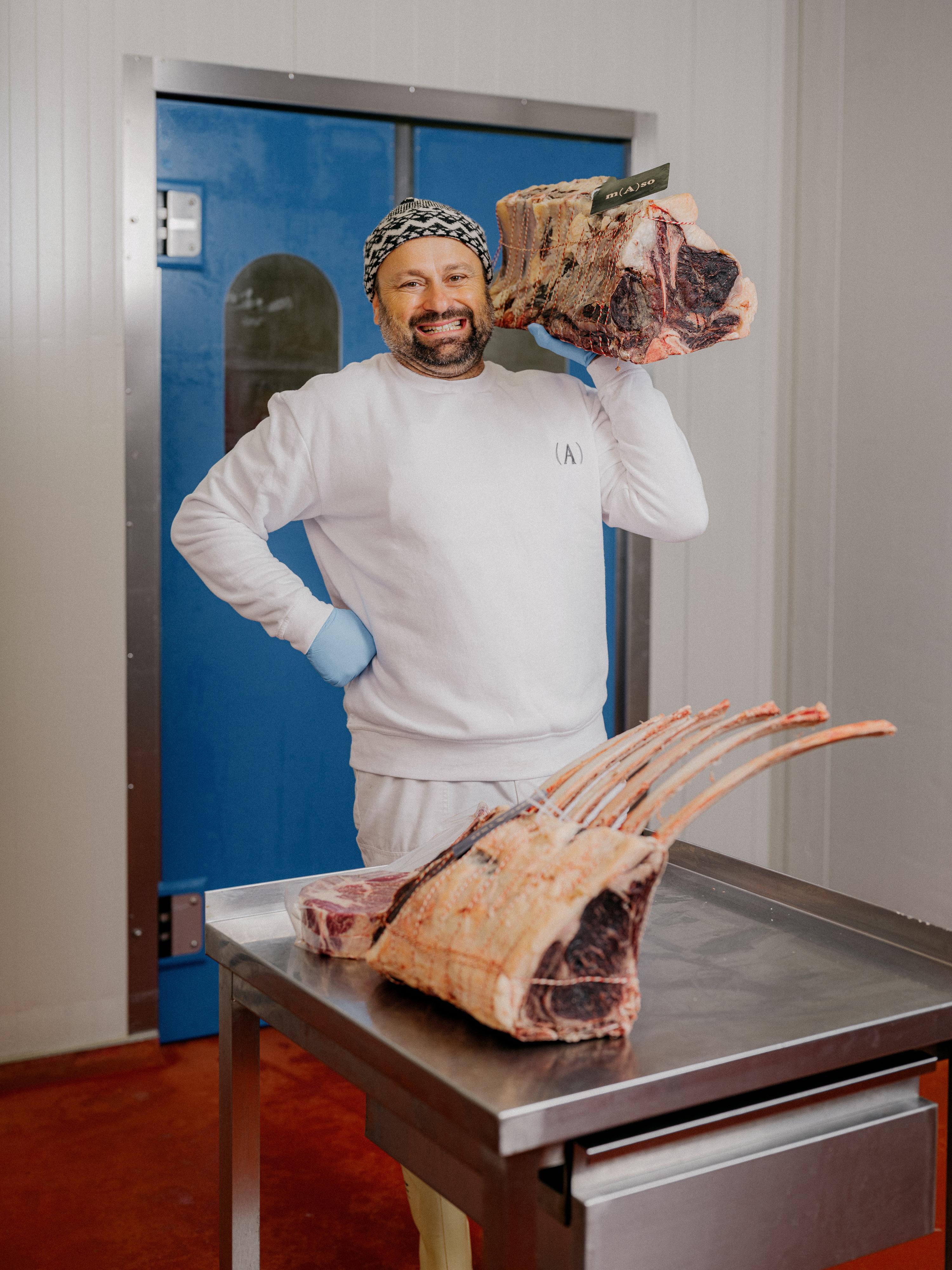 František Kšána držící vyzrálý hovězí hřbet v chladírně řeznictví.