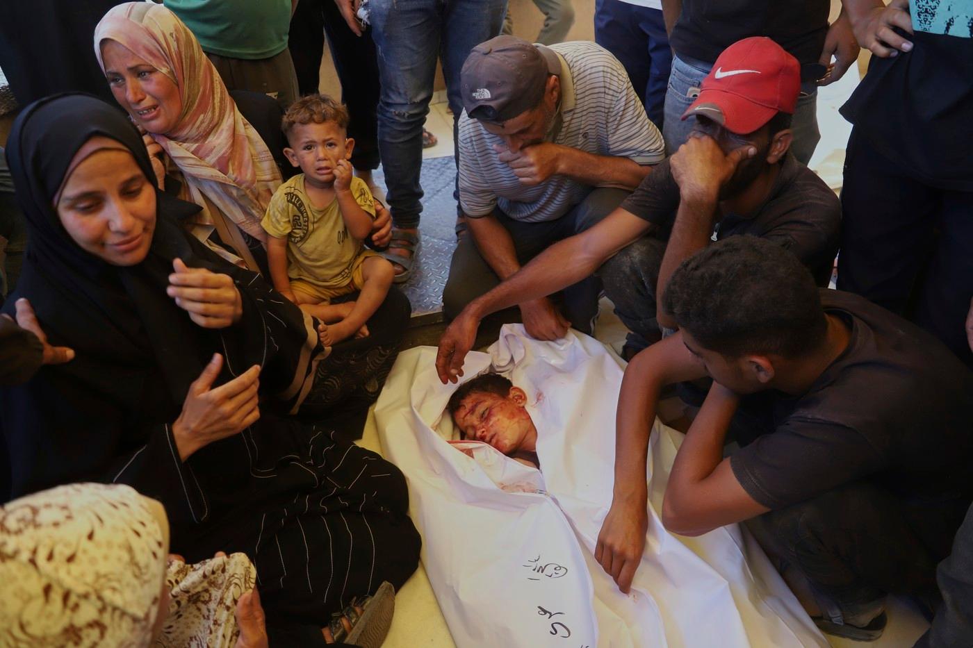 Palestinci truchlí nad tělem chlapce, který byl zabit při návratu z jednoho z distribučních center Gaza Humanitarian Foundation.