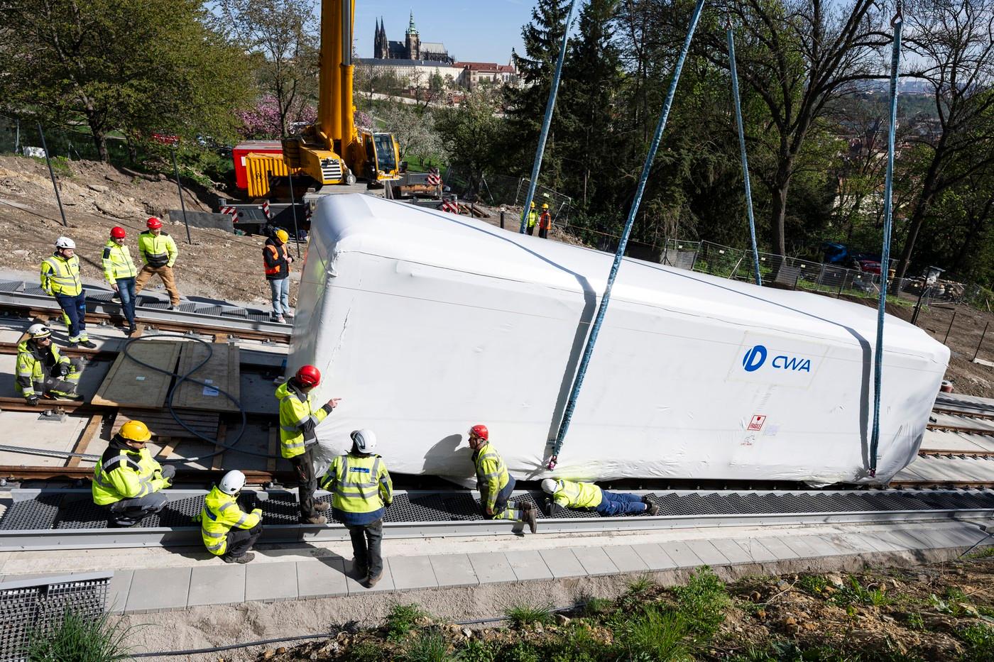 První ze dvou nových vozů lanové dráhy Petřín je ukládán na zrekonstruovanou trať