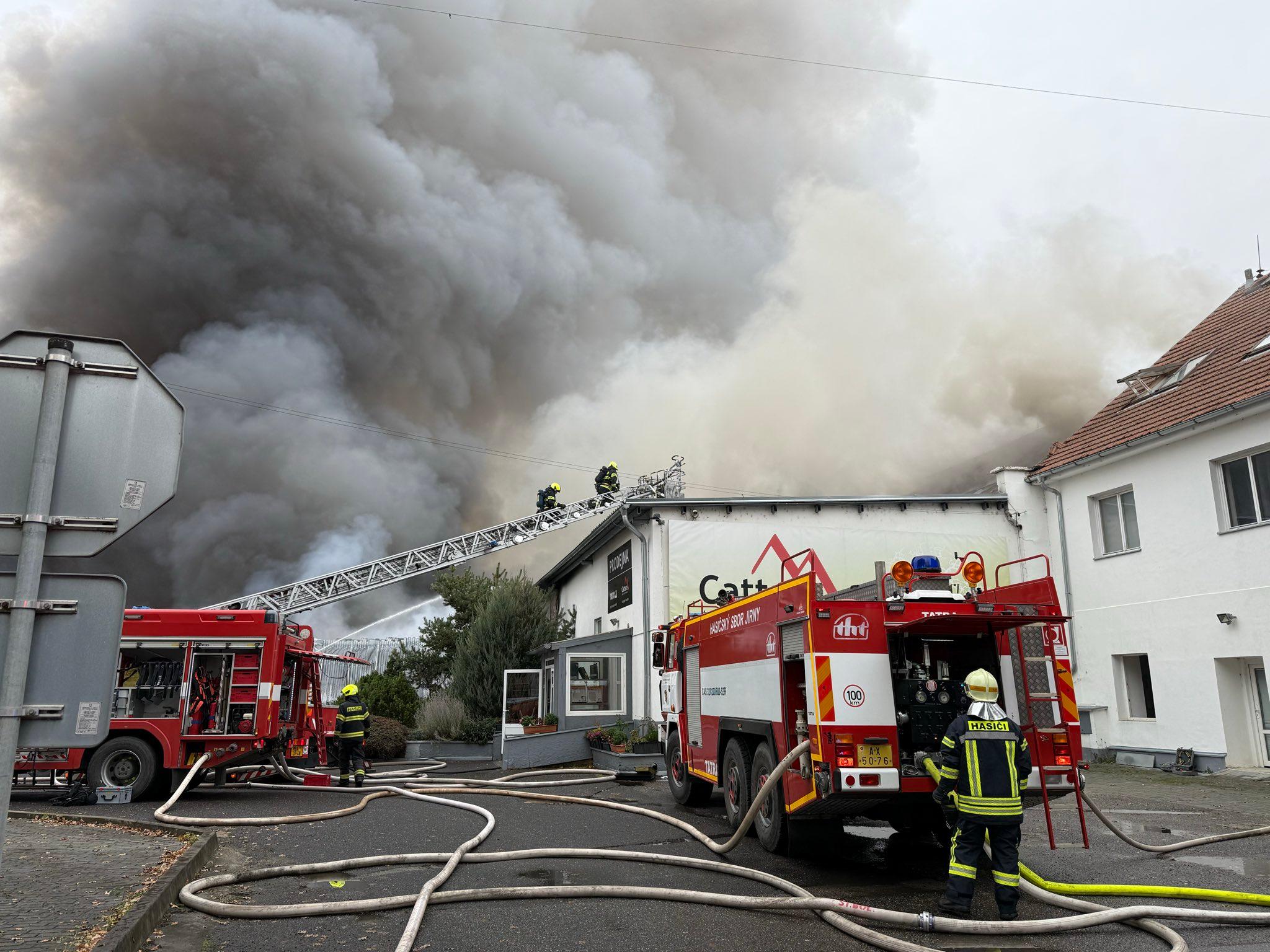 Hasiči zasahují u požáru haly v Nehvizdech u Prahy, vyhlásili třetí stupeň poplachu. Hala má rozměry 50 krát 20 metrů, hasiči chrání okolní objekty.