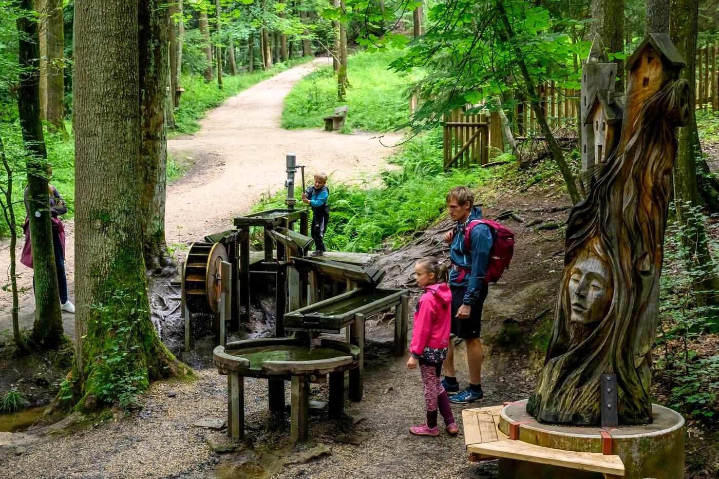 Lidé si hrají s vodními prvky u vesničky domečků s názvem Mlýnky na trase turistického okruhu Vyhlídky – Brand, který vede za městem přes udržovaný lesopark.