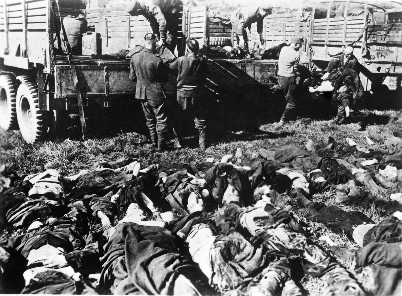 Esesáci skládají z nákladních aut vězně, kteří nevydrželi transport z Terezína. Při transportu bylo v těchto vozech vtěsnáno 100-150 lidí. Esesáci skládají z nákladních aut vězně, kteří nevydrželi transport z Terezína. Při transportu bylo v těchto vozech vtěsnáno 100-150 lidí.