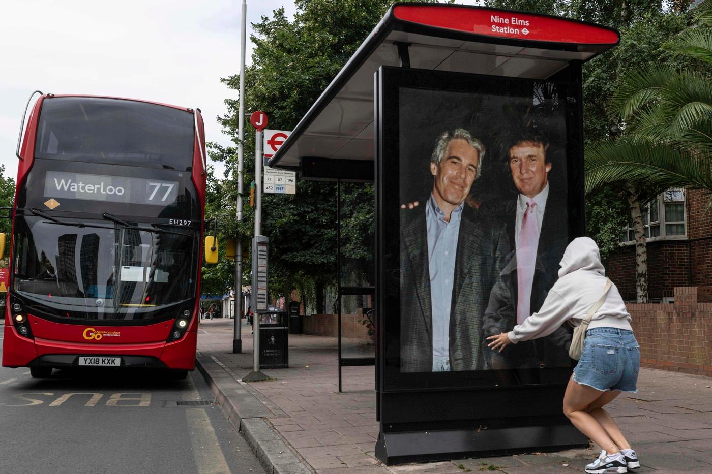 Aktivisté vyvěsili plakát zobrazující prezidenta Donalda Trumpa a Jeffreyho Epsteina poblíž velvyslanectví USA v Londýně, čtvrtek 17. července 2025. (AP Photo/Thomas Krych)