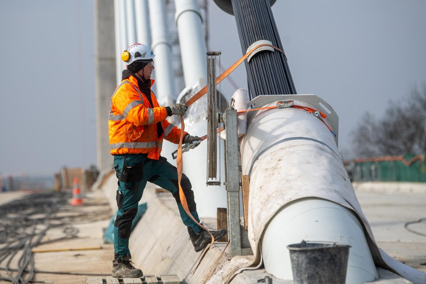 Zavěšování posledního svazku lan na budovaném lanovém mostě na severovýchodním obchvatu Pardubic, 25. února 2025, Pardubice.