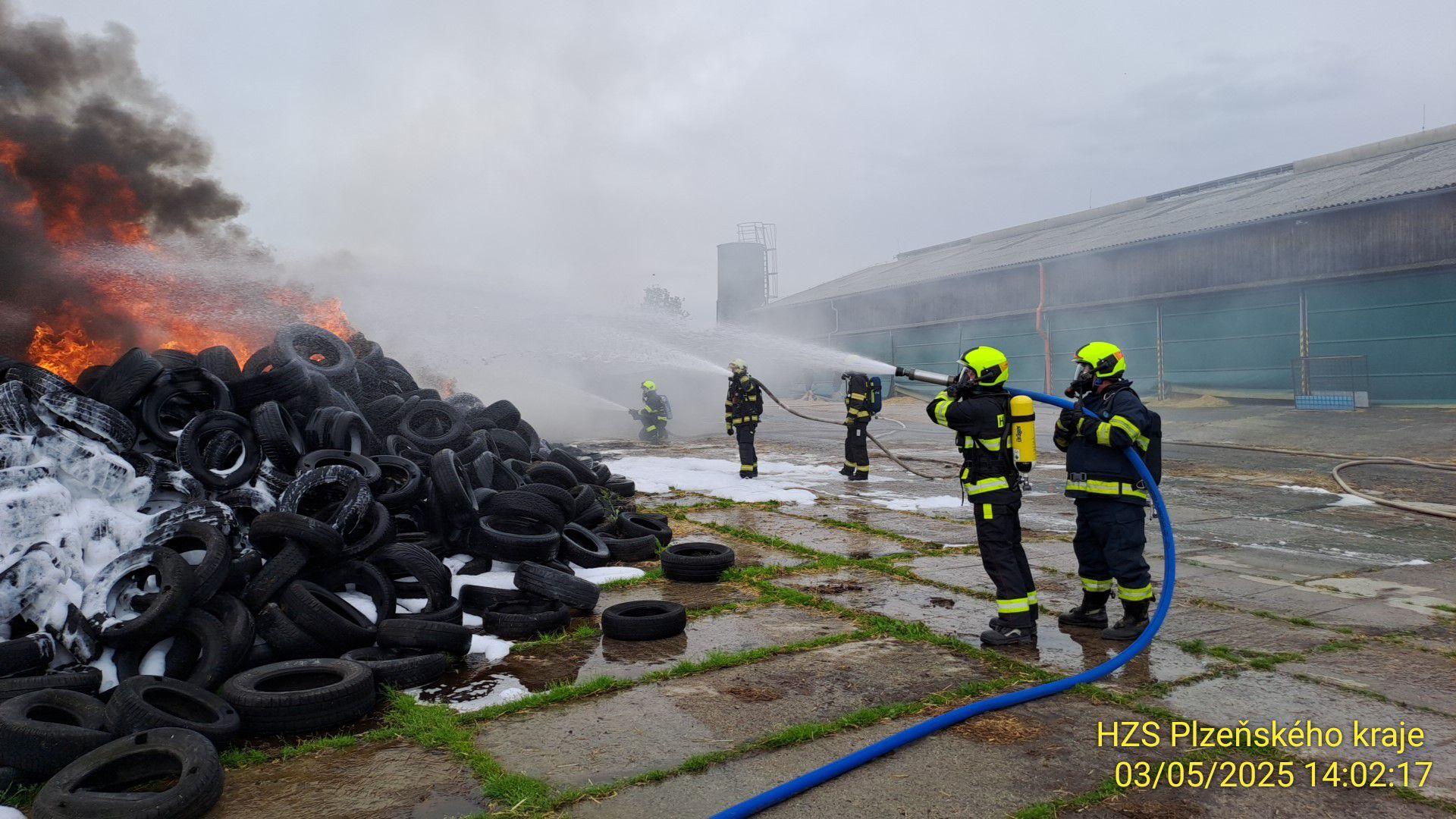 Hasiči zasahují u požáru v areálu zemědělské firmy v Žákavě na jižním Plzeňsku. Vyhlásili druhý stupeň požárního poplachu. Hoří hromada pneumatik.